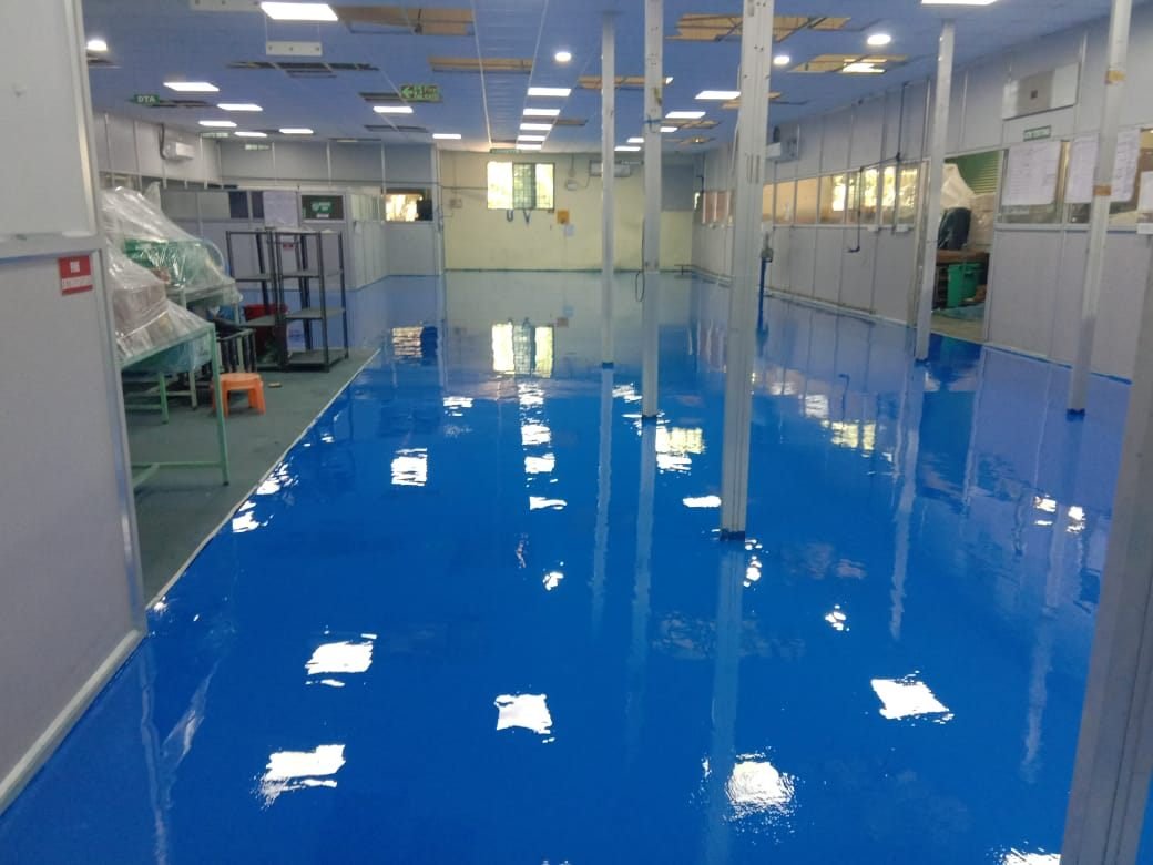 Glossy blue epoxy floor in a clean production corridor